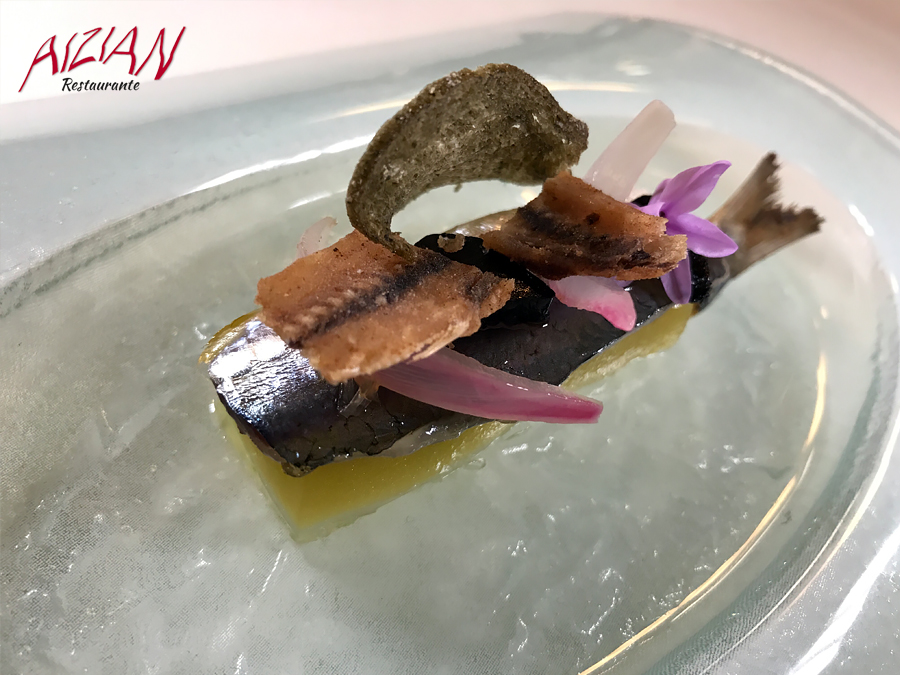 Lomo de sardina sobre gel de aceite a la brasa cebolla morada encurtida ajo negro y espinas crujientes aizian